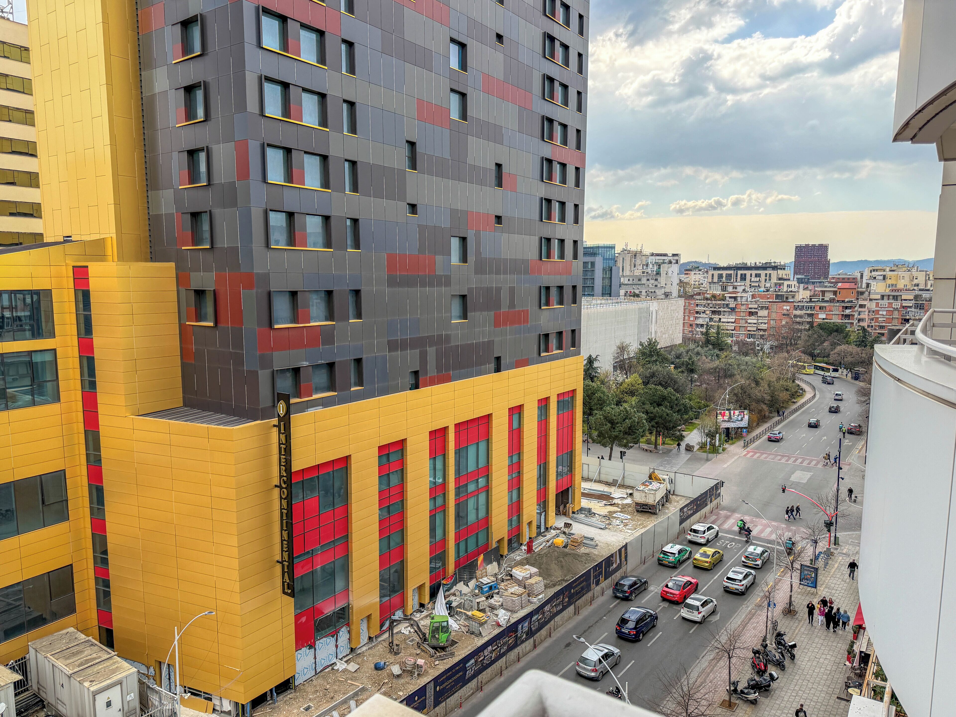 A multi-story building with a yellow facade and red accents, featuring large windows and a visible 'Continental' sign.