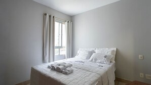 Ein Schlafzimmer mit Bett, Vorhängen und einem Fenster.
