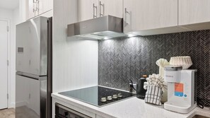 A modern kitchen with stainless steel appliances, a herringbone-patterned backsplash, and a built-in oven. - Pioche Peak by Avantstay Scenic Studio Retreat Spa Access Minutes to Skiing + Main Street (Park City)