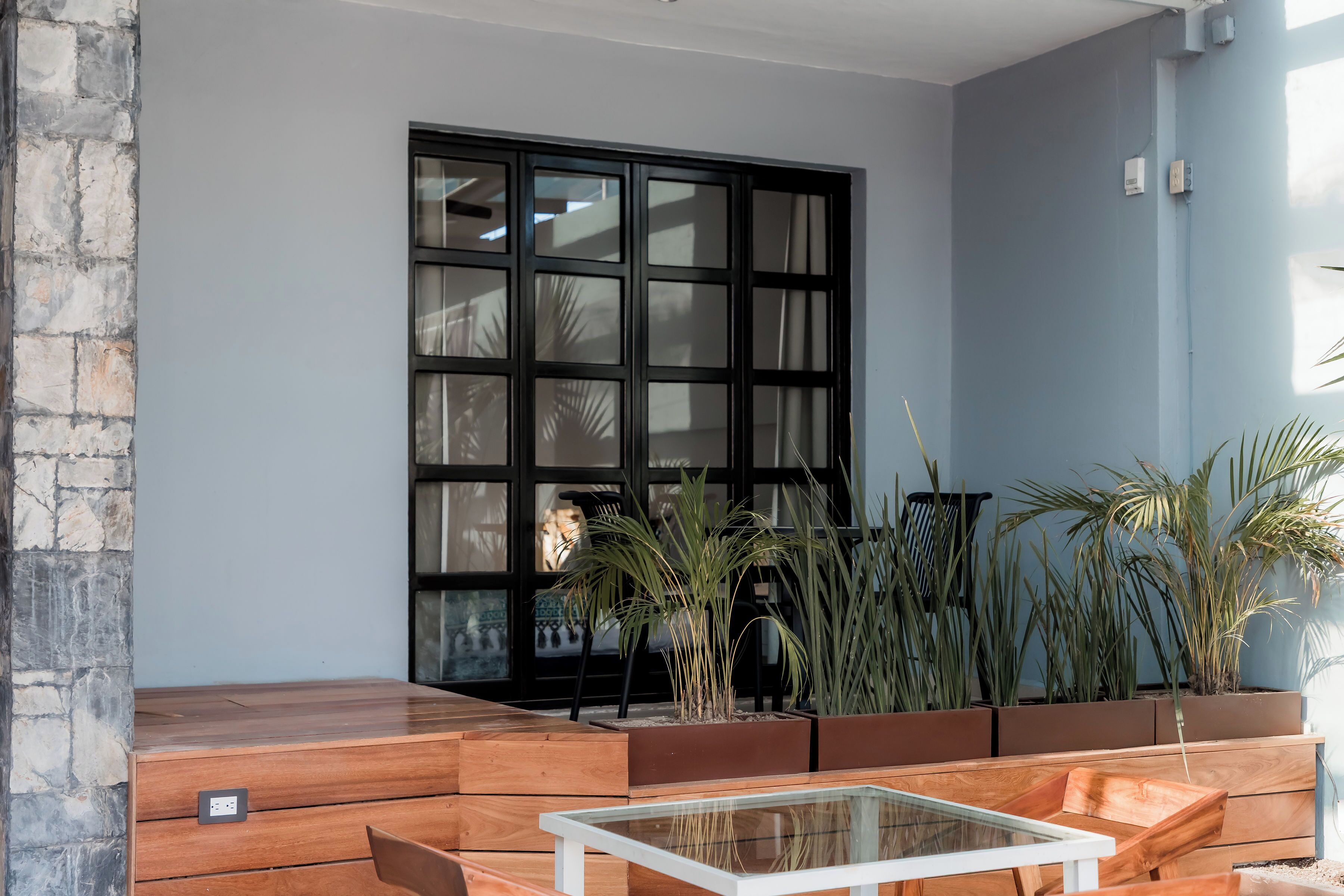 A modern room with a large window, built-in planters, and a glass-top table.