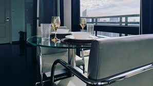 A dining area with a glass table, two chairs, a bowl, and two wine glasses. - Executive Studio w/ Sunset View - Makati CBD (Makati)