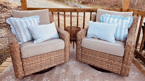 Two wicker chairs with checkered pillows on a wooden deck. - Adorable 1-bedroom studio bus in charming Wears Valley (Sevierville)