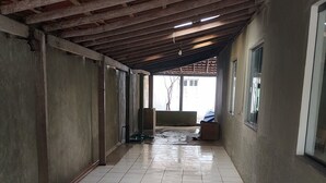 A corridor with tiled flooring, exposed wooden beams, and a window on the right. - Prado, Where it all began (Prado)