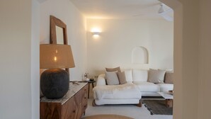 A cozy living room with a sofa, a lamp, and a small table. - Yema House - Naoussa Bay (4666+369 Protorgia, Greece)