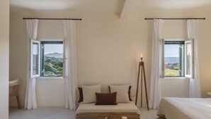 A bedroom with a bed, two windows with curtains, a bedside table, and a lamp. - Yema House - Naoussa Bay (4666+369 Protorgia, Greece)