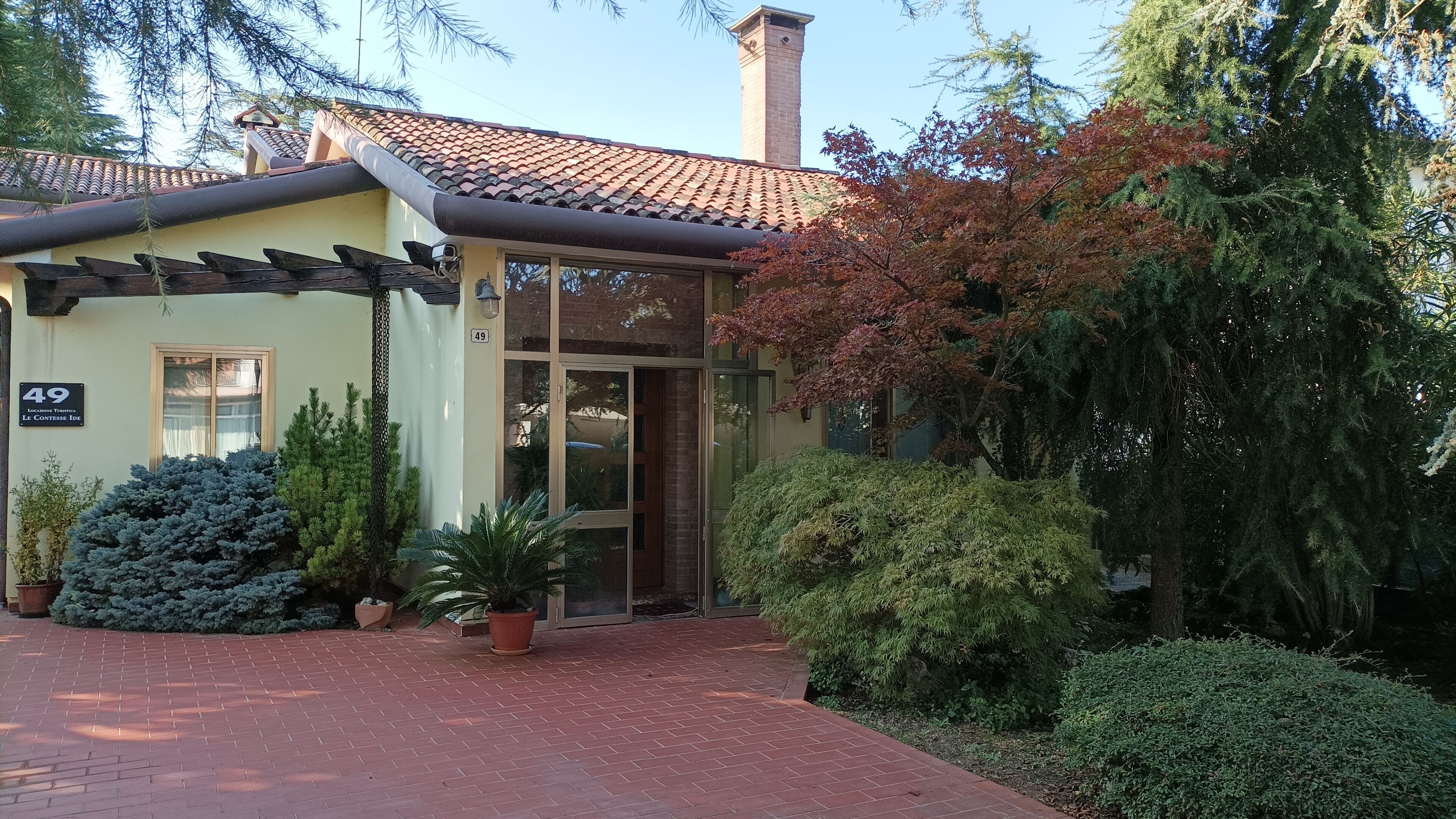A building with a tiled roof, a door, and a number 49 sign.