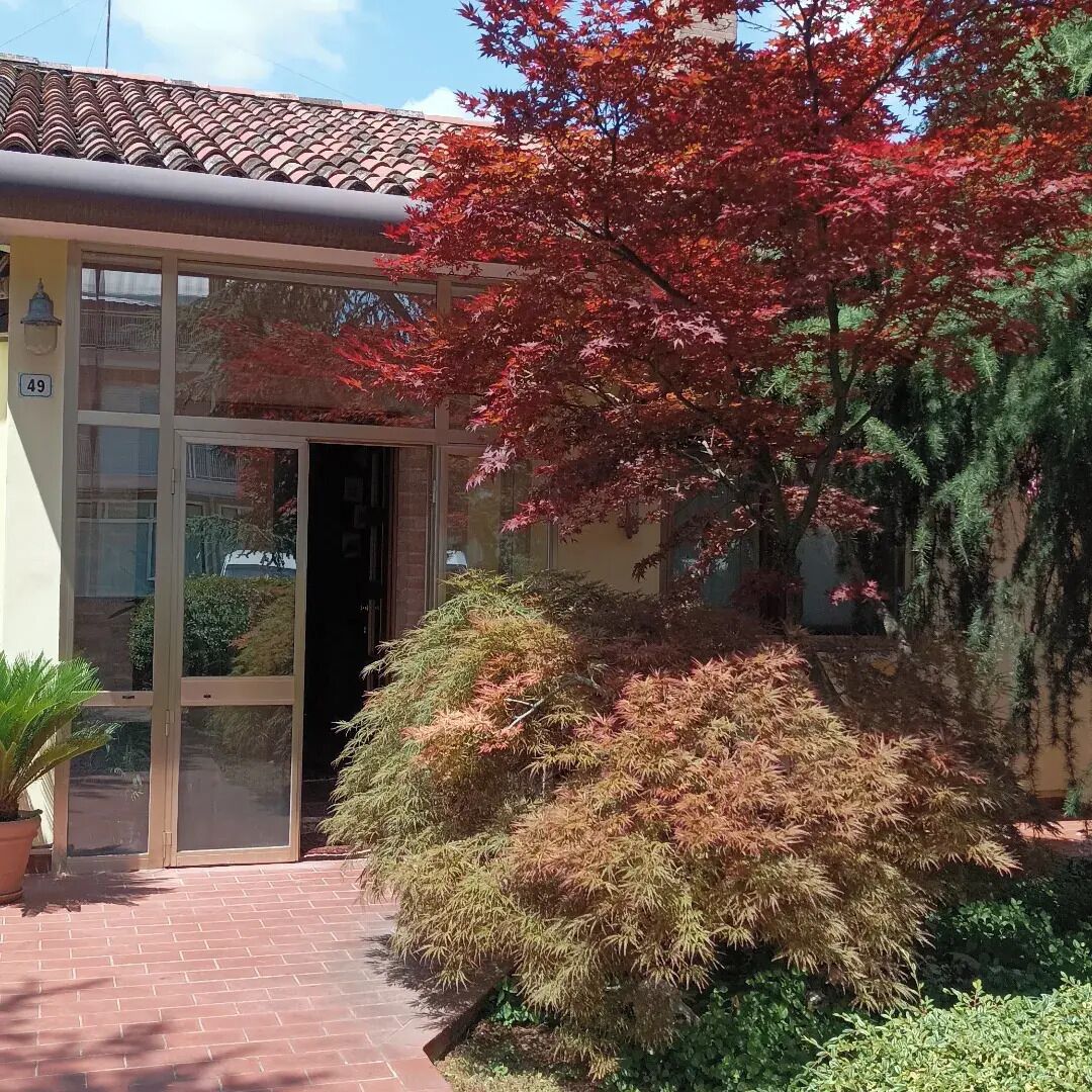 A building with a tiled roof, a glass entrance, and a brick pathway leading to the entrance.