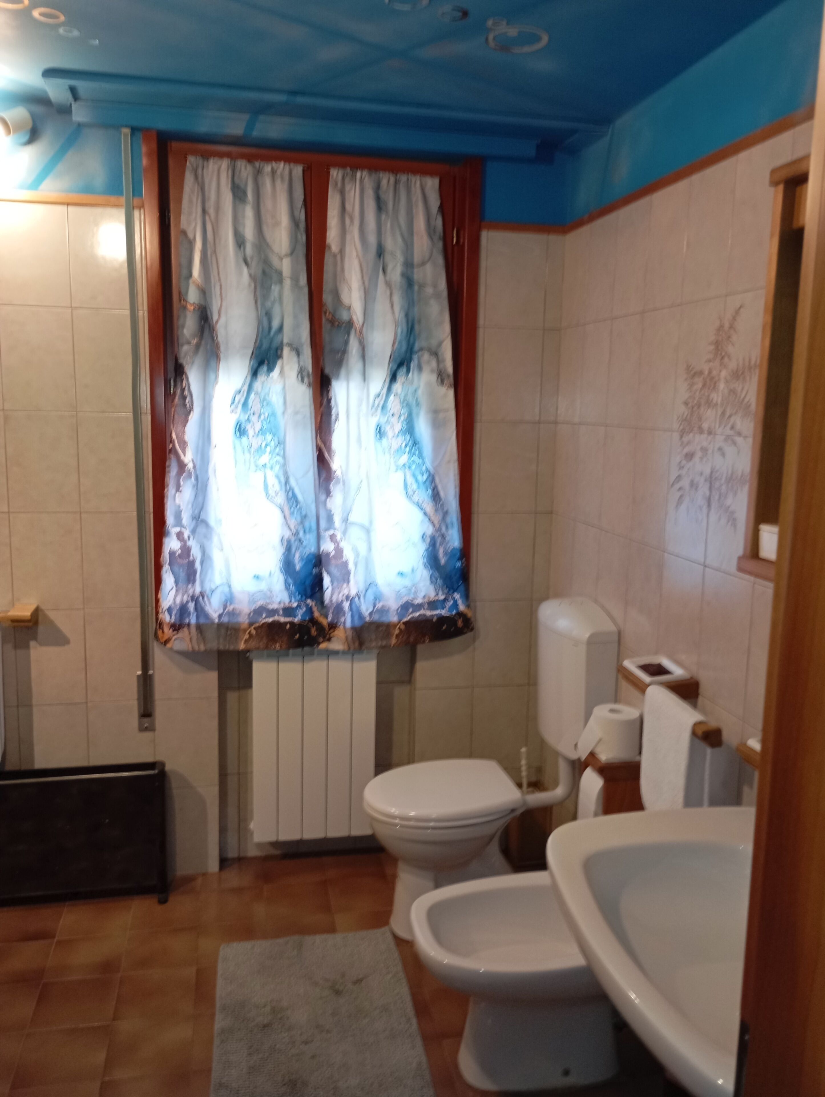 Une salle de bain comprenant des toilettes, un bidet et un espace douche.