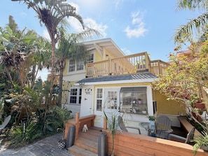 A two-story house with a balcony, a front porch, and a small shop. - `Oasis` Historic Beachside Cottage 3/2 (Indian Rocks Beach)
