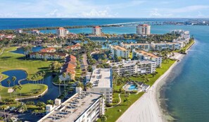 Ein Küstenhotel mit mehreren Gebäuden, einem Strand und einer Marina.
