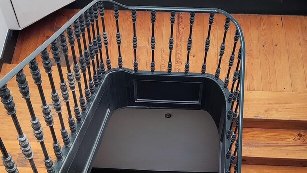 A staircase with a metal railing, wooden steps, and a white wall. - Cozy Suite in Bairro Alto Shared House (Lisboa)