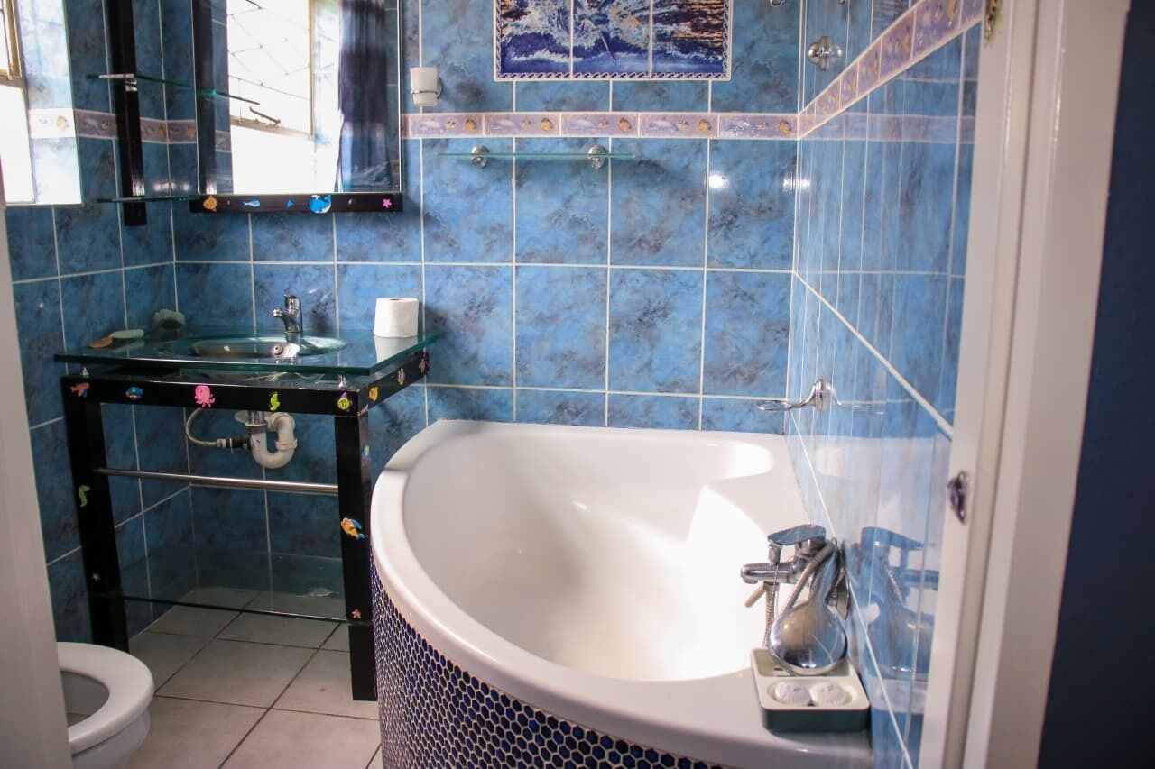 Une salle de bain avec un lavabo en verre, une baignoire et des toilettes.