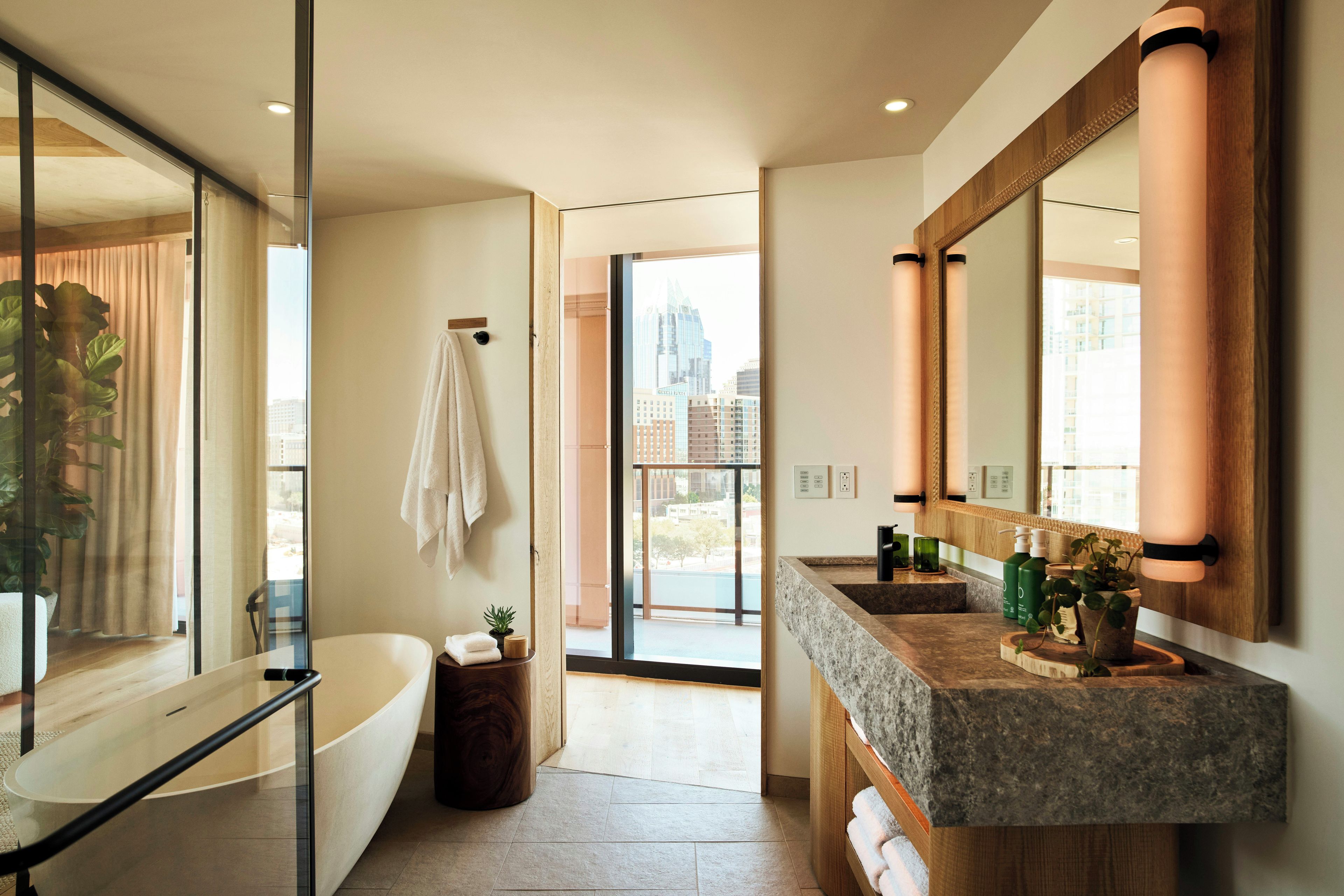 Ein modernes Badezimmer mit einer Badewanne, einem großen Spiegel und einem Waschtisch mit Spüle.