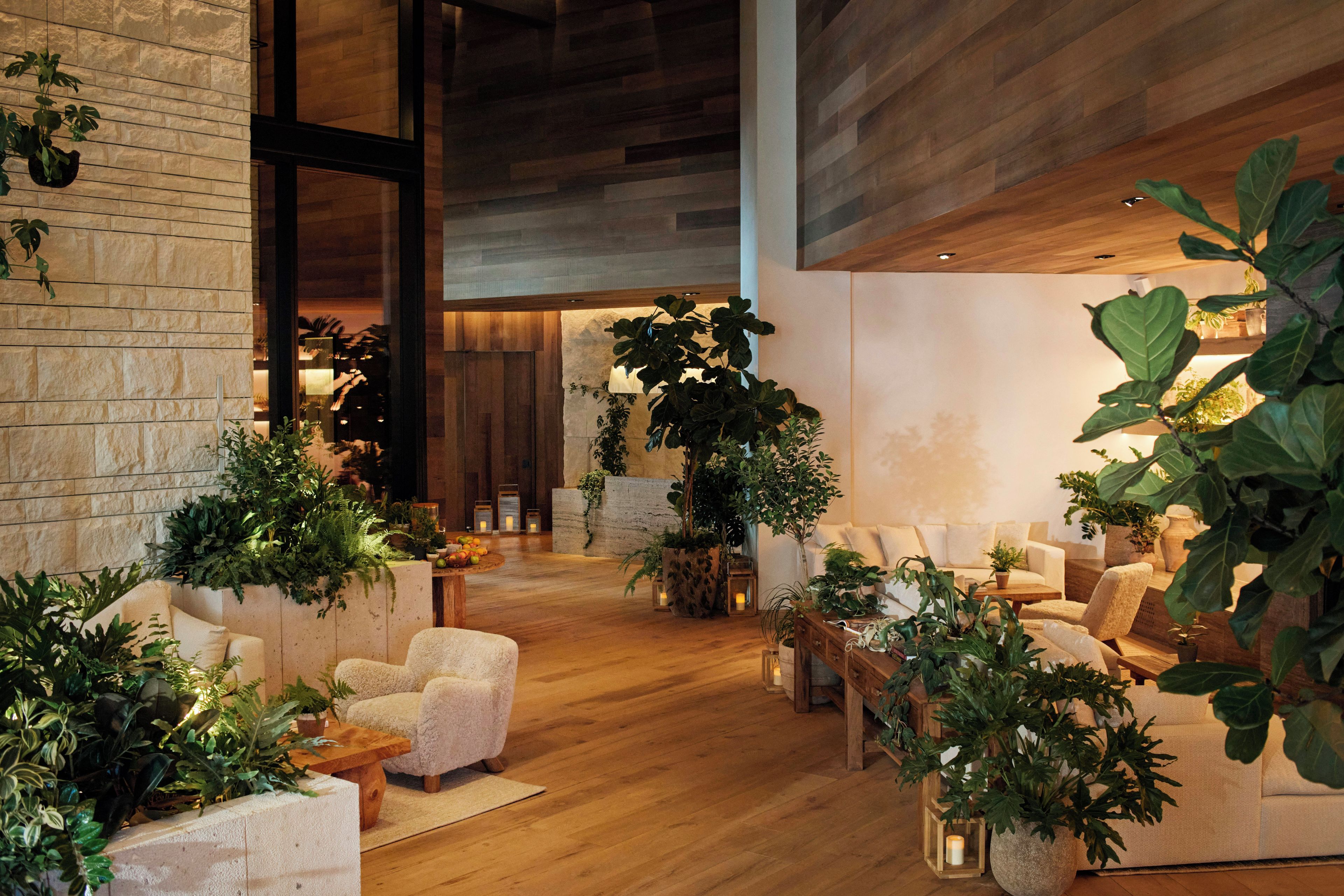 A spacious lobby with a high ceiling, wooden flooring, and a variety of seating arrangements.