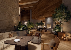 A spacious indoor area with a wooden ceiling, a sofa, a round coffee table, and several potted plants. - 1 Hotel Austin (Austin)