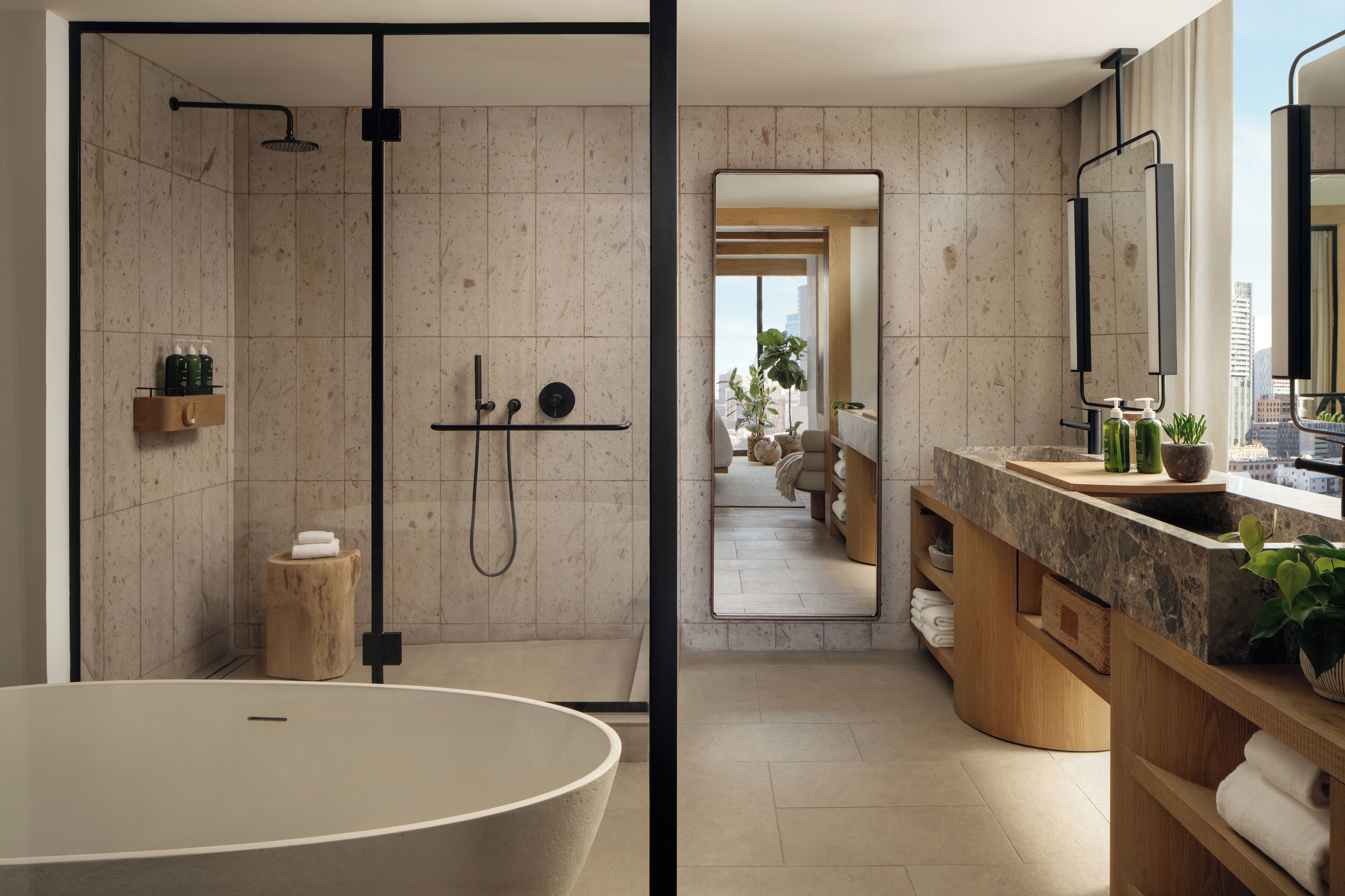 A modern bathroom with a freestanding bathtub, a walk-in shower, and a vanity with a large mirror.