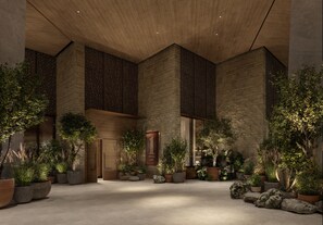 A hotel lobby with a modern design, featuring a large wooden ceiling, stone walls, and numerous potted plants. - 1 Hotel Austin (Austin)