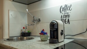 Eine Küche mit Kaffeemaschine, Spüle und einer Wand mit einer Kaffeebotschaft.
