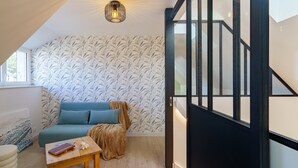 Ein modernes Interieur mit einem blauen Sofa, einem Holztisch und einer Wand mit Muster.