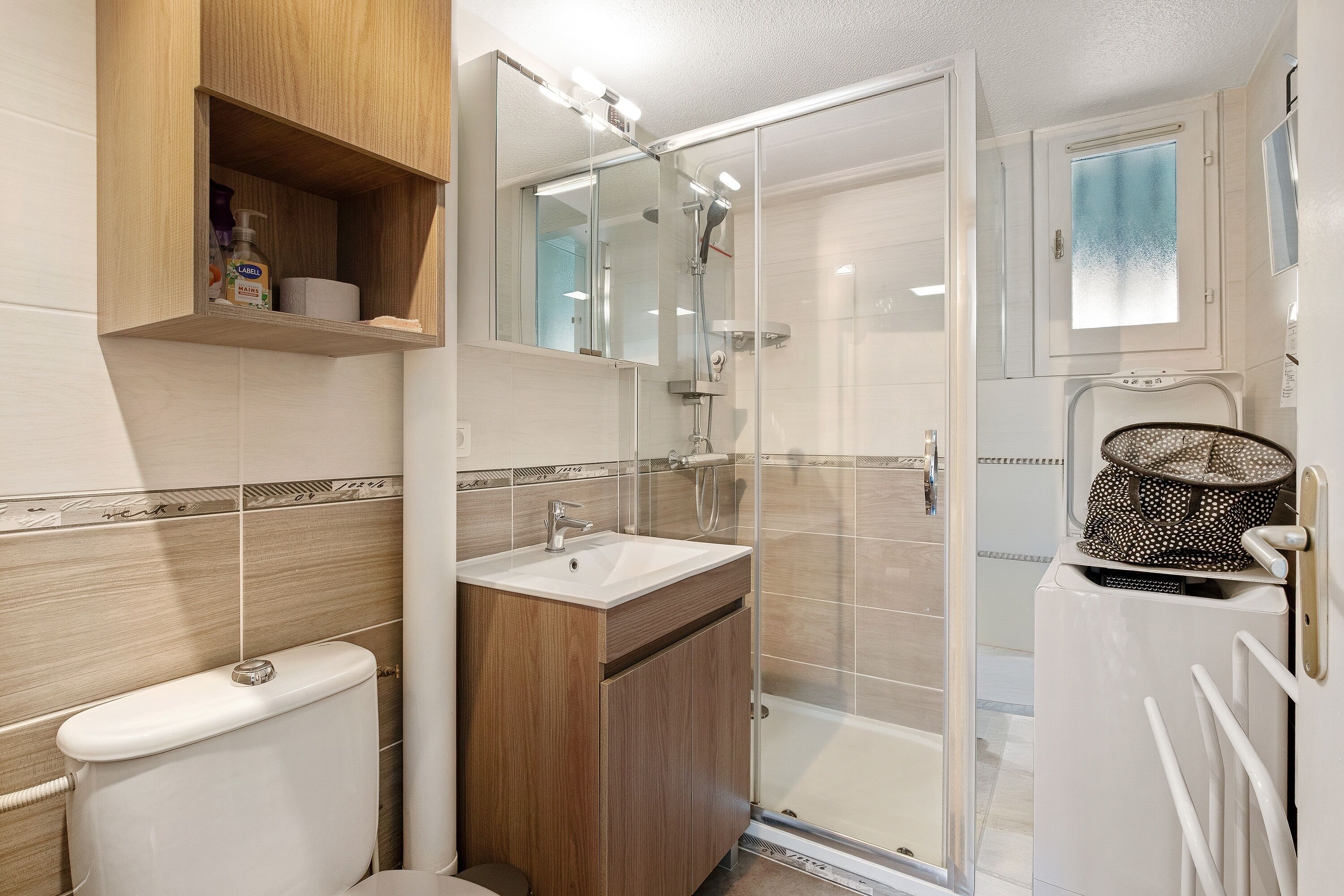 Een badkamer met toilet, wastafel en douche.