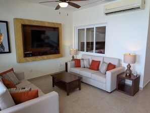 A living room with a sofa, coffee table, TV, and lamps. - 1373  Ocean Front 2 bedroom (Bajos de Chila)