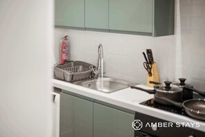 Una cucina con lavello, scolapiatti e fornello.