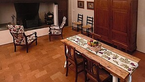 A dining area with a wooden table, chairs, a fireplace, and a cabinet. - La Funambola B&B (Figline e Incisa Valdarno)