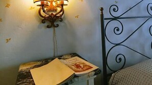 A room with a bed, a nightstand with a lamp, and a wall with floral wallpaper. - La Funambola B&B (Figline e Incisa Valdarno)