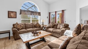 Ein Wohnzimmer mit zwei Sofas, einem Couchtisch und einem Deckenventilator.