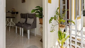 A doorway leading to a room with a chair, a small table, and a potted plant. - Cozy Apartment Rental in Puerto Plata, Dominican Republic (Puerto Plata)