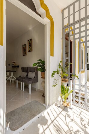 A doorway leading to a room with a chair, a small table, and a potted plant. - Cozy Apartment Rental in Puerto Plata, Dominican Republic (Puerto Plata)
