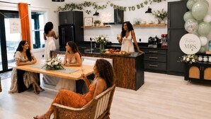 Una cocina moderna con una isla central, armarios negros y un banderín decorativo.