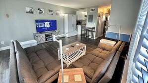 Een moderne woonkamer met een hoekbank, een salontafel en een televisie.