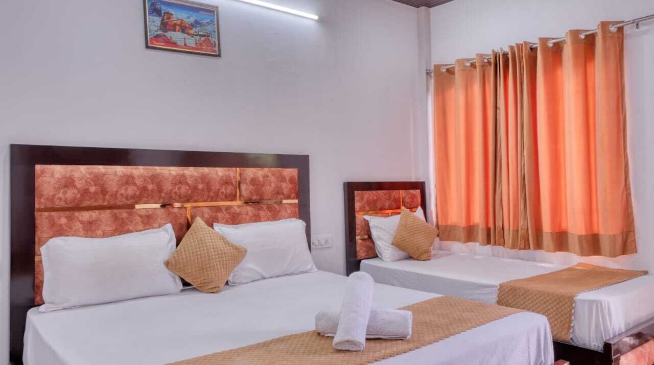 A hotel room with two beds, a headboard, pillows, a curtain, and a painting on the wall.