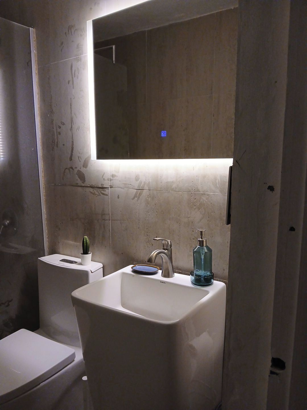 A bathroom with a white sink, a mirror above it, and a toilet.