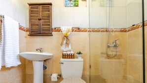 Ein Badezimmer mit Standwaschbecken, Toilette und Dusche.