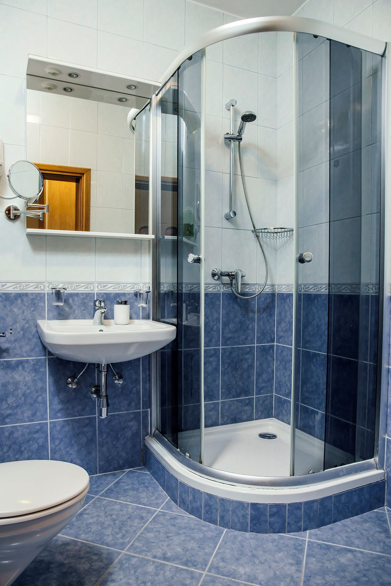 Une salle de bain avec une douche à parois de verre, un lavabo et des toilettes.