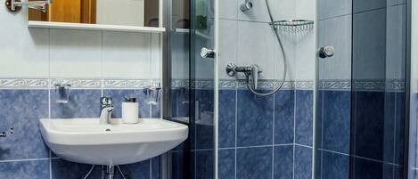 Une salle de bain avec une douche à parois de verre, un lavabo et des toilettes.