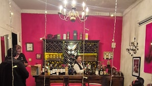 A bar area with a counter, seating, and a wine rack.