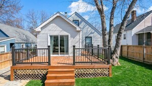 Une maison avec une terrasse, un escalier et une cour clôturée.