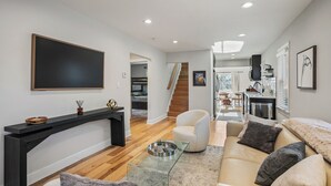 Un salon moderne avec un canapé, un fauteuil et une table basse en verre.