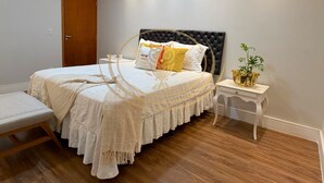 Une chambre à coucher avec un lit, une table de chevet, un banc et une porte.