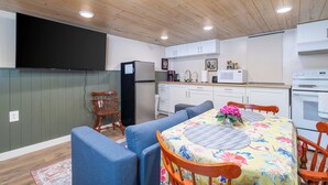 A compact kitchen with white cabinets, a microwave, and a refrigerator.
