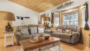A cozy living room with two sofas, a wooden coffee table, and a lamp.