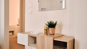 A modern bathroom with a wooden vanity, a mirror, a small potted plant, and a scale. - Ortensie House (Padua)
