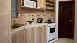 A kitchen with a microwave, stove, oven, and various kitchen utensils. - Suite at Lomas de Urdesa walk to Tennis Federation (Guayaquil)