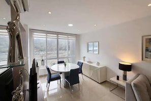 Una sala de estar moderna con comedor, ventanas amplias y diseño minimalista.