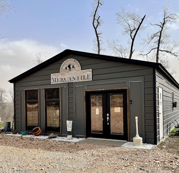 A building labeled 'The Mercantile' with a sign indicating it's a handmade market and retreat.