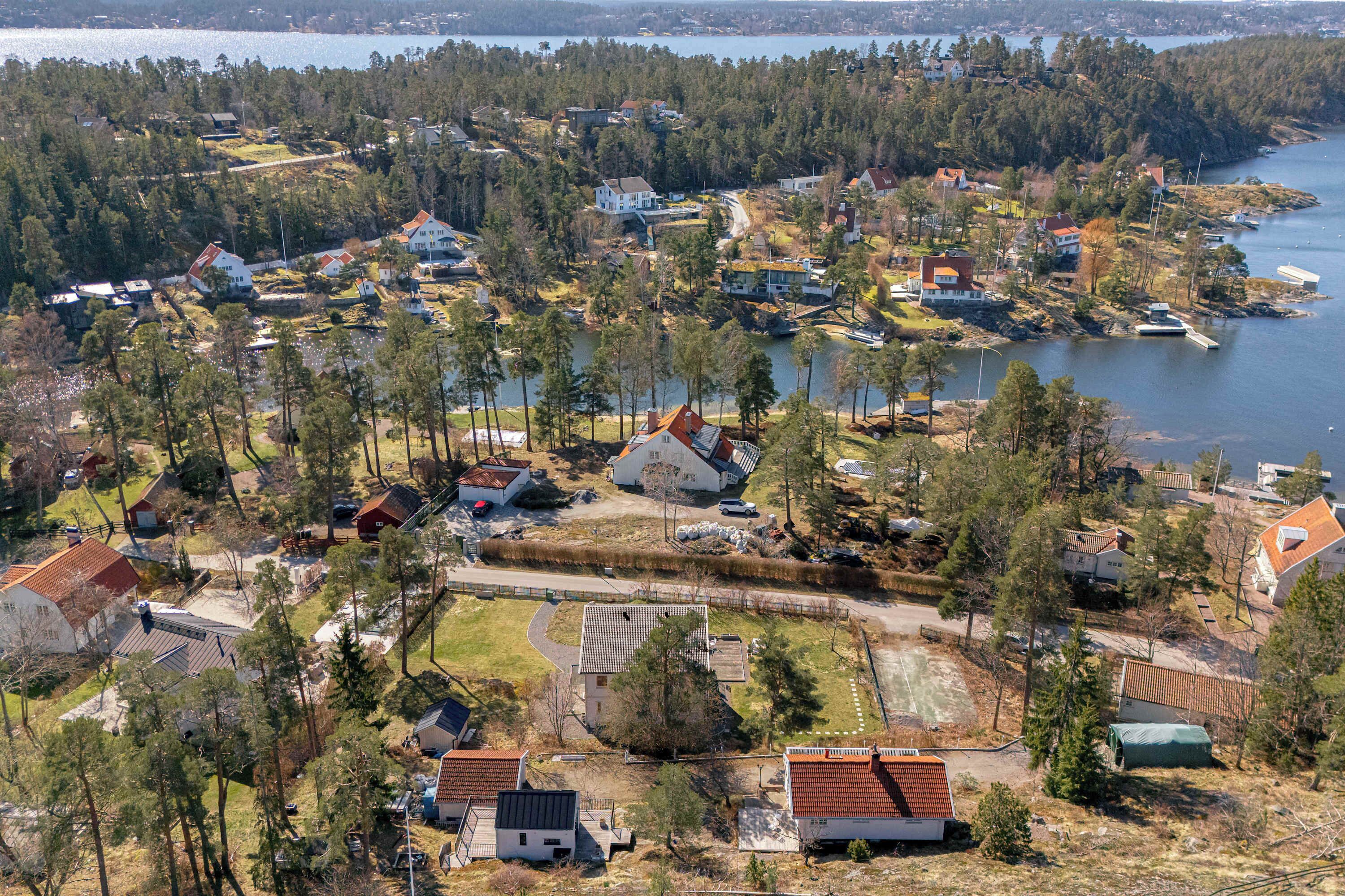 Vue aérienne d’un quartier résidentiel avec des maisons, un lac et un quai.