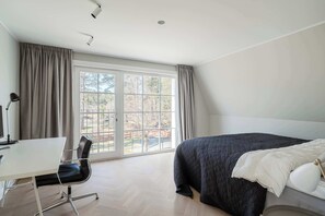 Una camera da letto con un letto, una scrivania e una sedia.